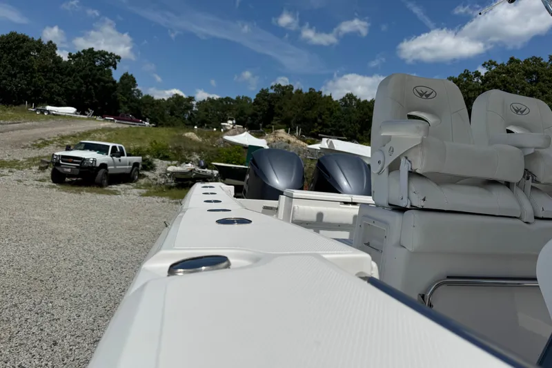 Slide: The Image of 2013 Southport 27 FE boat with dual engines and seating, parked near a pickup truck. - 37