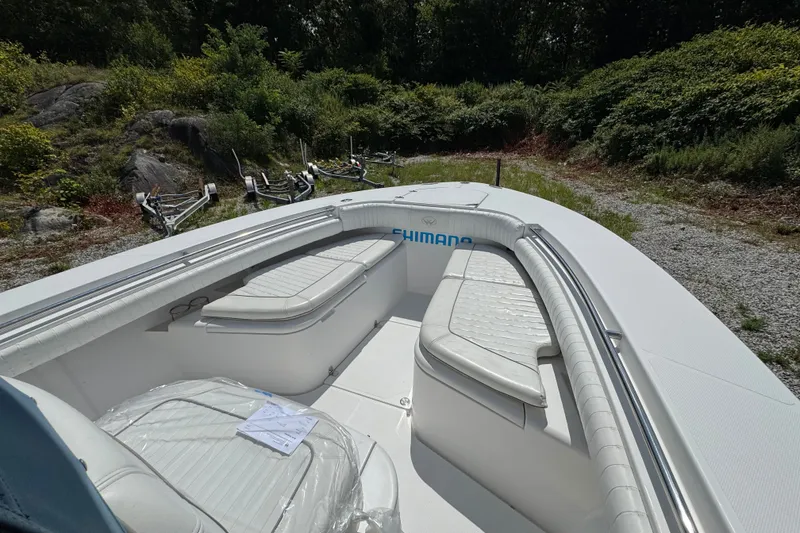 Slide: The Image of 2013 Southport 27 FE boat interior with white seating, parked outdoors. - 40