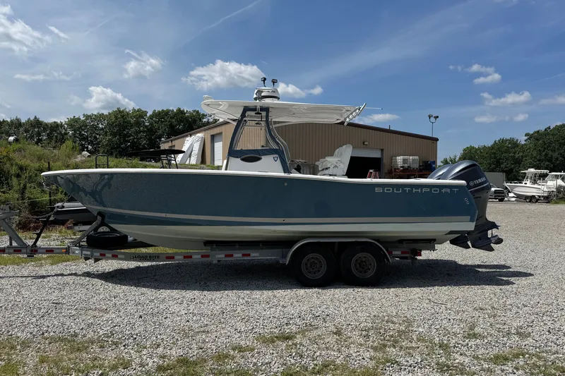Slide: The Image of 2013 Southport 27 FE boat on trailer, parked outdoors near a warehouse. - 7
