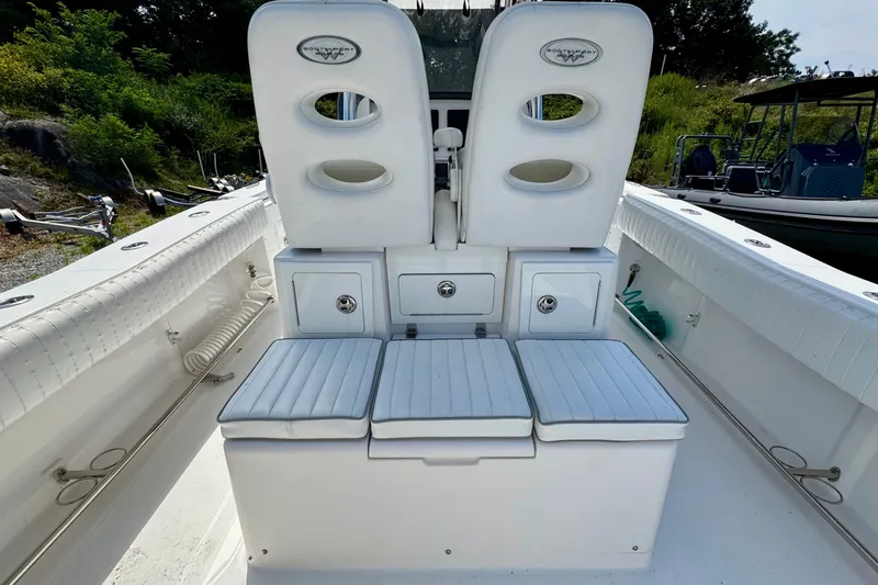 Slide: The Image of 2013 Southport 27 FE boat interior with white cushioned seating and storage compartments. - 26