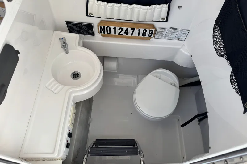 Slide: The Image of Interior of 2013 Southport 27 FE boat featuring a compact sink and toilet. - 30