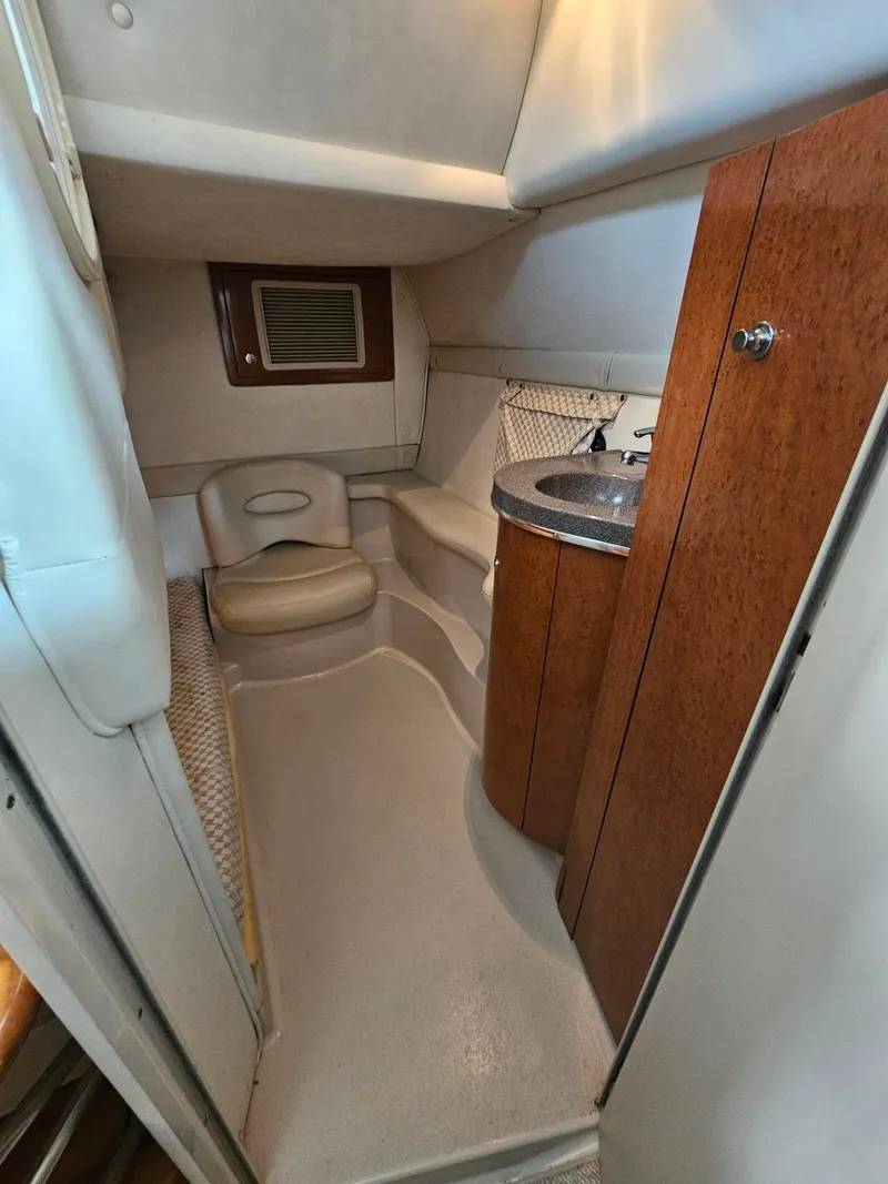 Slide: The Image of The cabin of a 2001 Doral 330se features a sink, wooden cabinets, and a cushioned bench. - 9