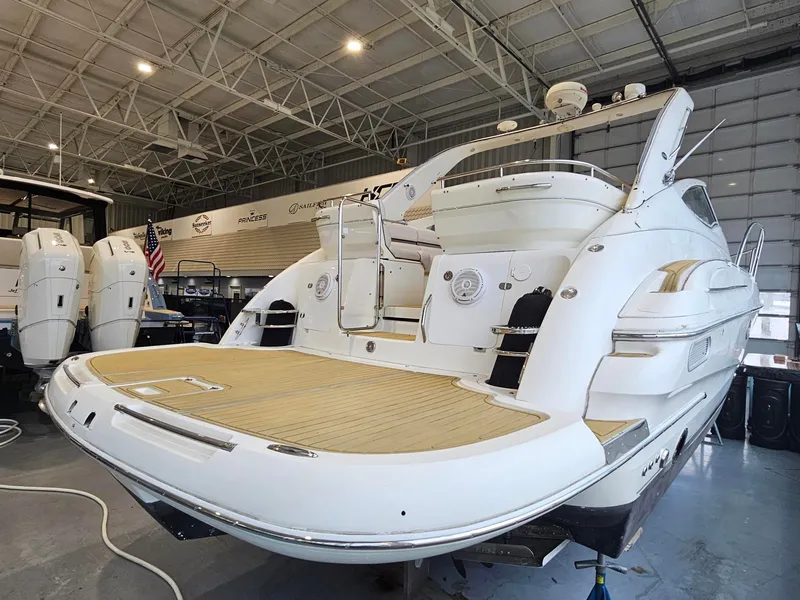 Slide: The Image of A 2001 Doral 330se in a warehouse. It features a spacious wooden aft deck. - 7