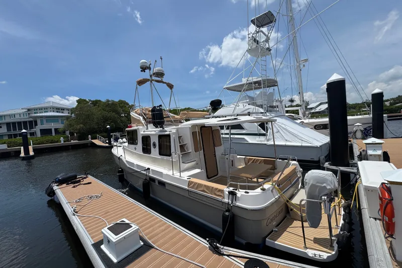 Slide: The Image of 2020 Ranger Tugs R-31 CB docked at marina under clear blue sky. - 2