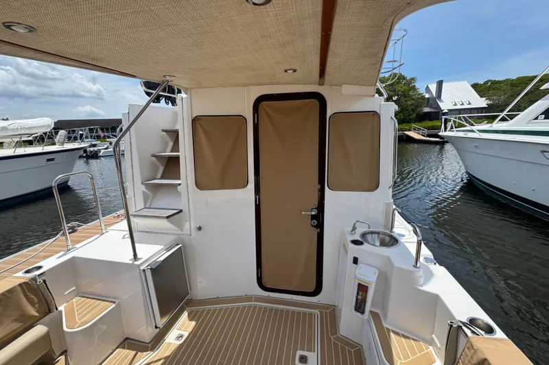 Slide: The Image of 2020 Ranger Tugs R-31 CB boat deck with seating, sink, and dockside view. - 6