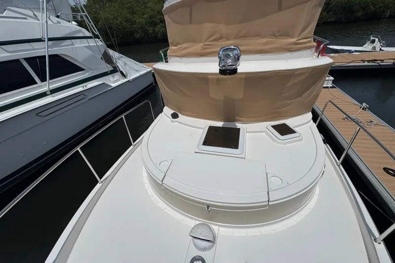 Slide: The Image of 2020 Ranger Tugs R-31 CB boat docked, featuring a spacious deck and beige canopy. - 33
