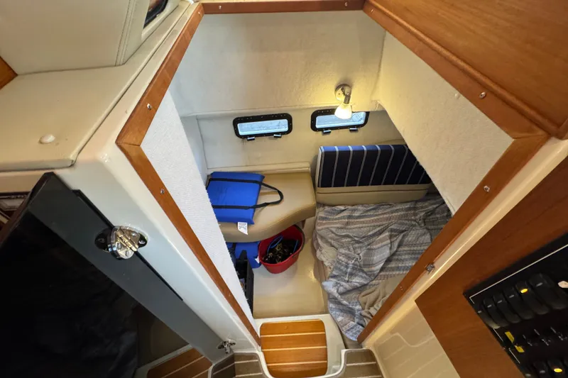 Slide: The Image of 2020 Ranger Tugs R-31 CB cabin interior with cozy sleeping area and storage. - 17