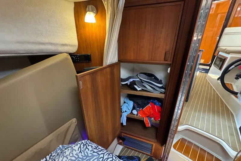 Slide: The Image of Interior of 2020 Ranger Tugs R-31 CB with open wooden cabinet and clothing storage. - 28