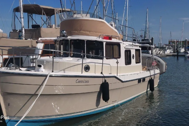 The Image of 2020 Ranger Tugs R-31 CB boat docked in marina, surrounded by other vessels. - 0