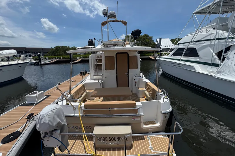 Slide: The Image of 2020 Ranger Tugs R-31 CB docked at marina, rear view with seating area. - 5