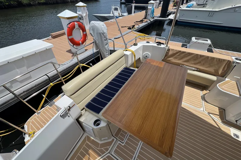 Slide: The Image of 2020 Ranger Tugs R-31 CB boat deck with seating and wooden table at marina. - 8
