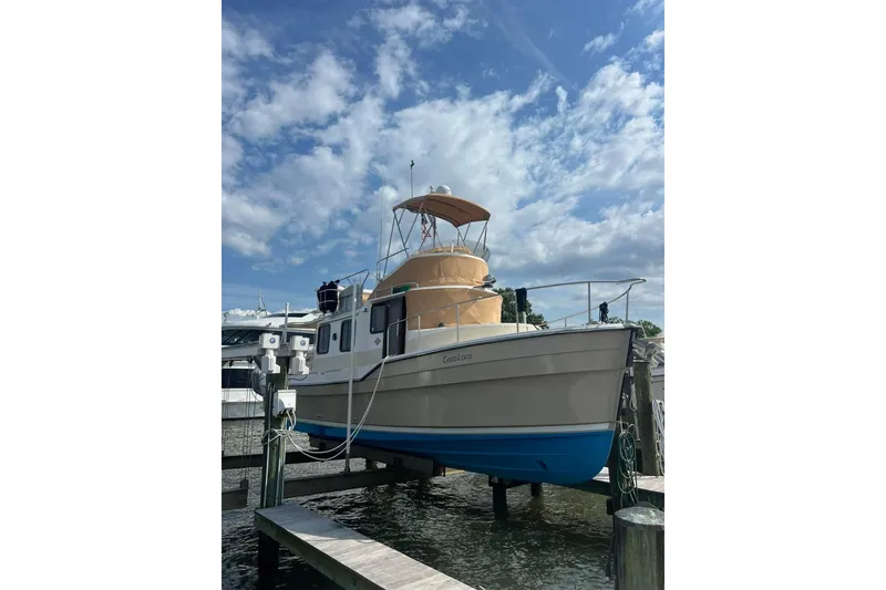 Slide: The Image of 2020 Ranger Tugs R-31 CB boat docked under a partly cloudy sky. - 1