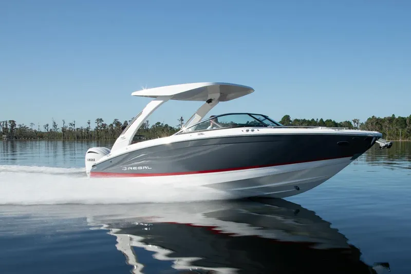 Slide: The Image of Manufacturer Provided Image: 2026 Regal LX6 boat cruising on calm water under clear blue sky. - 7