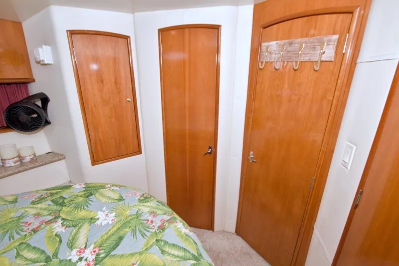 Slide: The Image of Interior of 2001 Carver 466 Motor Yacht with wooden doors and tropical bedding. - 45