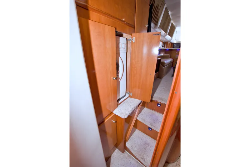 Slide: The Image of Interior of 2001 Carver 466 Motor Yacht with open wooden cabinet and carpeted stairs. - 57