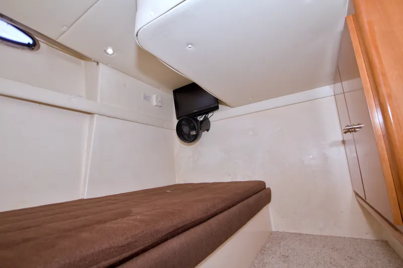 Slide: The Image of 2001 Carver 466 Motor Yacht interior cabin with brown cushioned bed and fan. - 53
