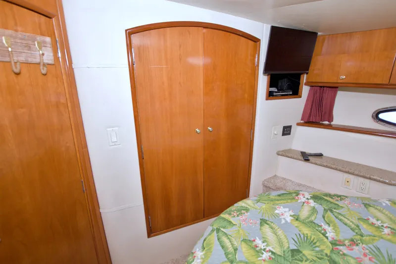 Slide: The Image of Interior of 2001 Carver 466 Motor Yacht with wooden cabinets and floral bedding. - 42