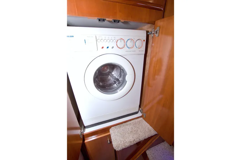 Slide: The Image of Washing machine inside 2001 Carver 466 Motor Yacht, wooden cabinetry, open door view. - 58