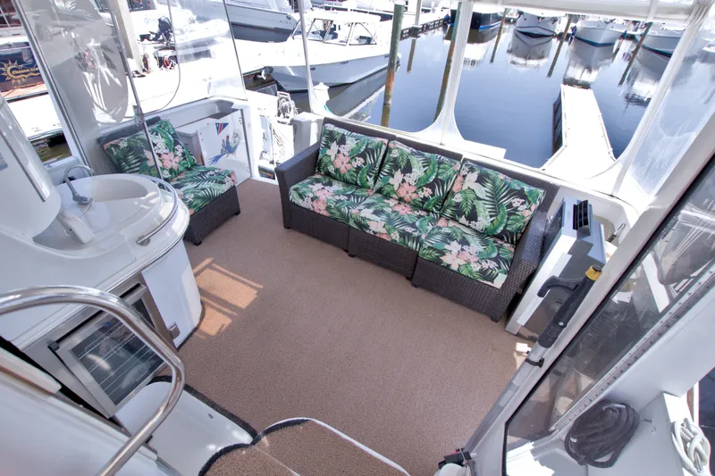Slide: The Image of Luxurious 2001 Carver 466 Motor Yacht interior with tropical-themed seating and marina view. - 30