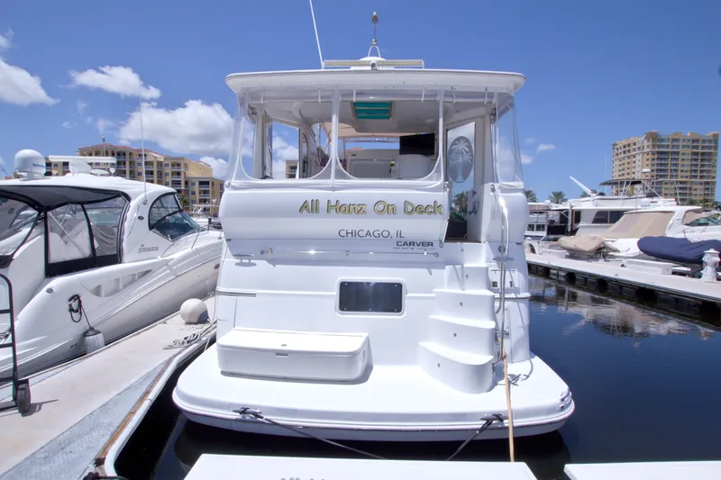 Slide: The Image of 2001 Carver 466 Motor Yacht docked at marina, clear sky, luxury boats nearby. - 3