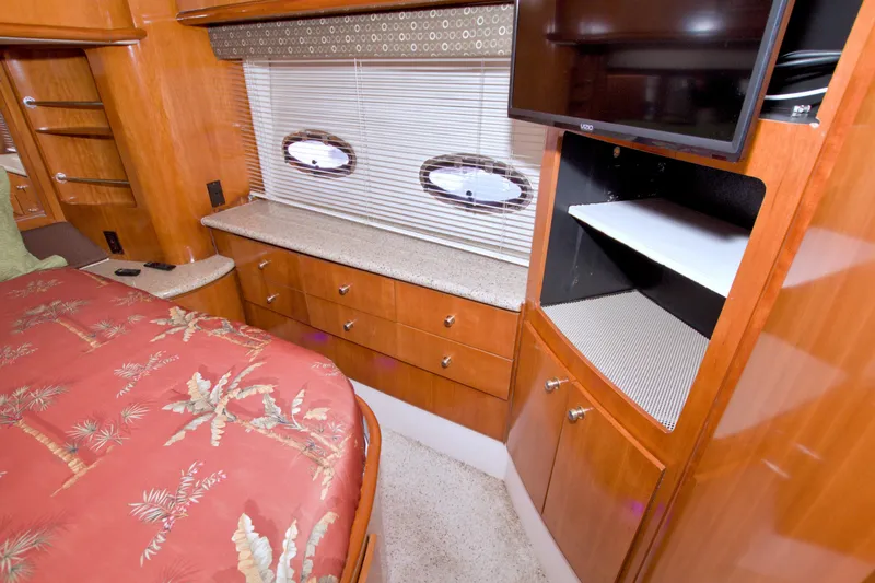 Slide: The Image of Interior of 2001 Carver 466 Motor Yacht with wood cabinetry and tropical-themed bedding. - 60