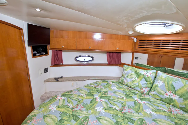Slide: The Image of Luxurious 2001 Carver 466 Motor Yacht bedroom with tropical bedding and wood cabinetry. - 43