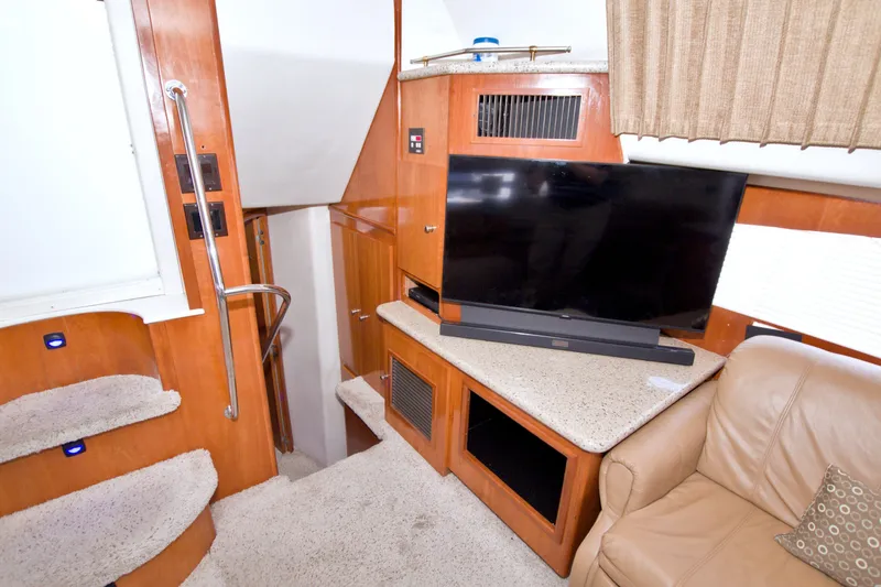 Slide: The Image of Interior of 2001 Carver 466 Motor Yacht with TV, stairs, and seating area. - 56