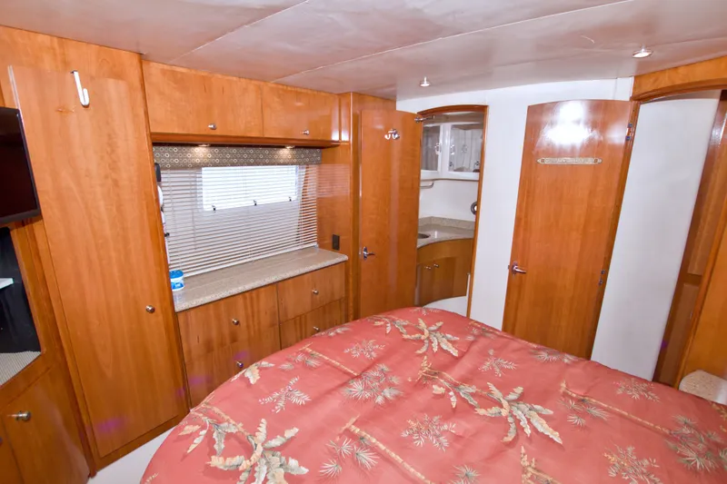 Slide: The Image of Interior of 2001 Carver 466 Motor Yacht with wood cabinetry and floral bedspread. - 62