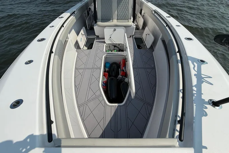Slide: The Image of 2023 Reef Runner 34CC boat interior with open storage compartments on the water. - 27