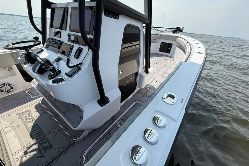 Slide: The Image of 2023 Reef Runner 34CC boat interior with advanced navigation controls on open water. - 19