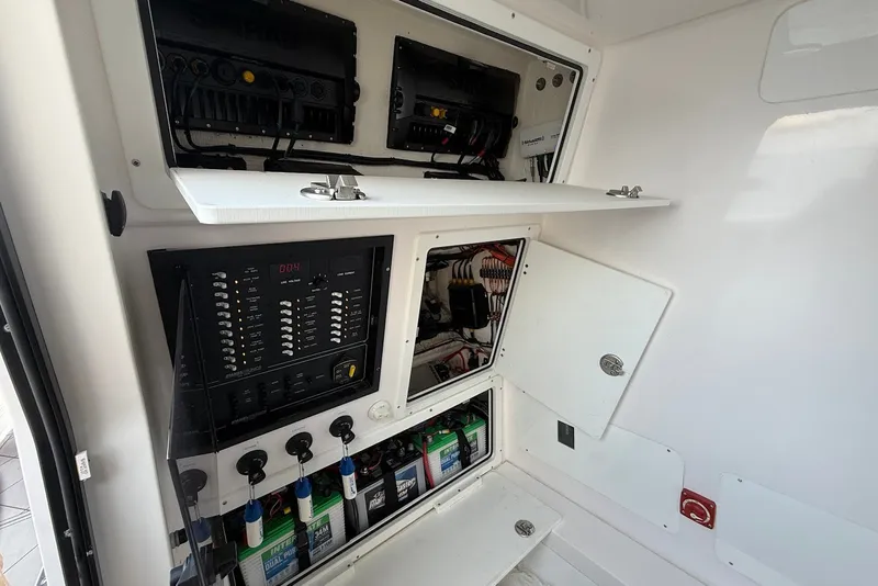 Slide: The Image of Electrical panel and storage compartments inside a 2023 Reef Runner 34CC boat. - 21
