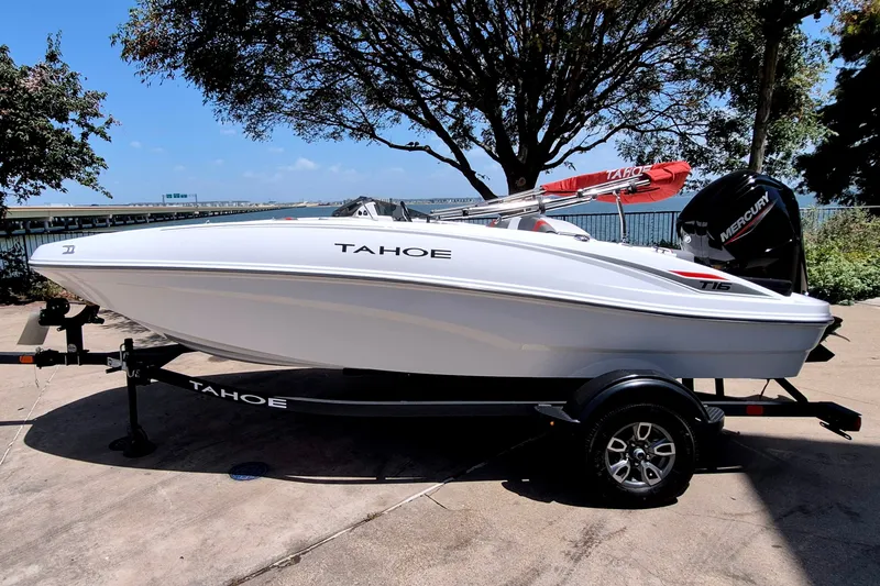 The Image of 2025 Tahoe T16 boat on trailer, parked near a scenic waterfront. - 0