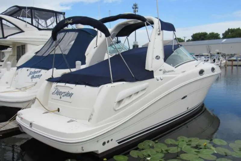 The Image of 2008 Sea Ray Sundancer 260 boat docked, featuring sleek design and blue canopy. - 0