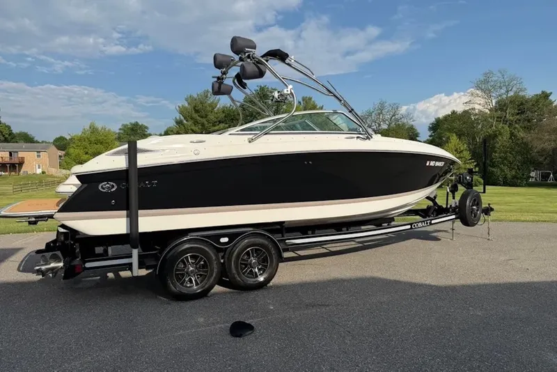 The Image of 2008 Cobalt 252 boat on trailer, parked outdoors under a clear blue sky. - 0