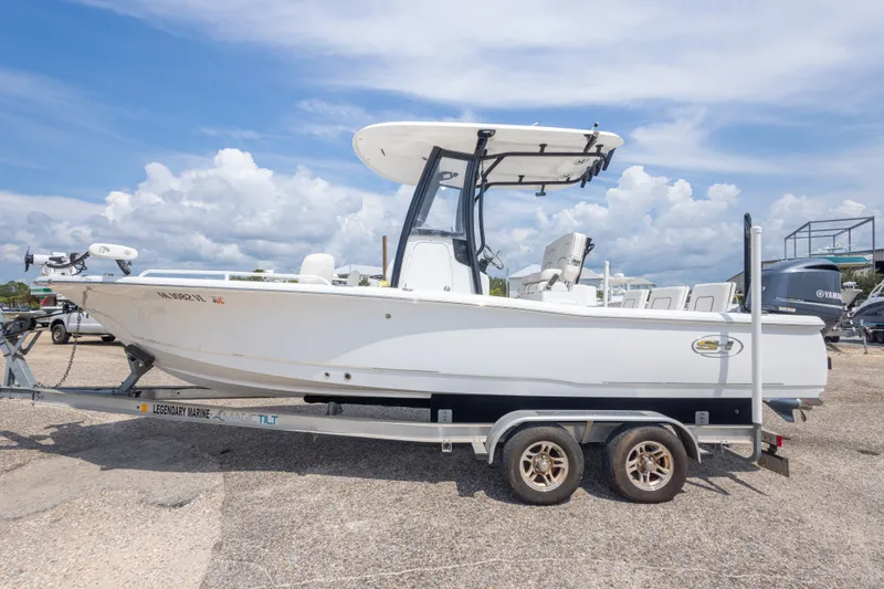Slide: The Image of 2019 Sea Hunt BX25FS boat on trailer under a clear blue sky. - 19