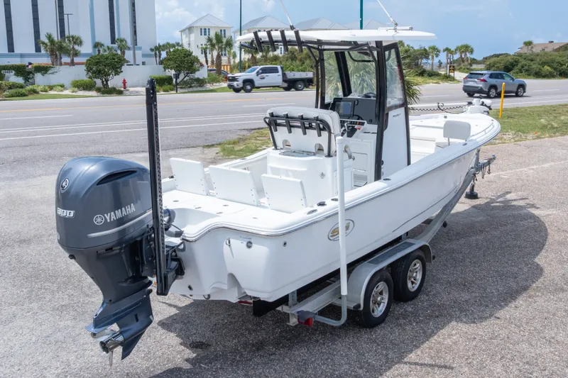 Slide: The Image of 2019 Sea Hunt BX25FS boat on trailer with Yamaha engine, parked near a road. - 48