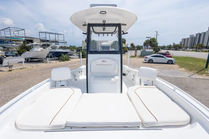 Slide: The Image of 2019 Sea Hunt BX25FS boat with cushioned seating, docked at a marina. - 43