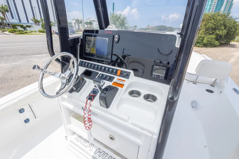 Slide: The Image of 2019 Sea Hunt BX25FS boat console with steering wheel, navigation screen, and controls. - 22