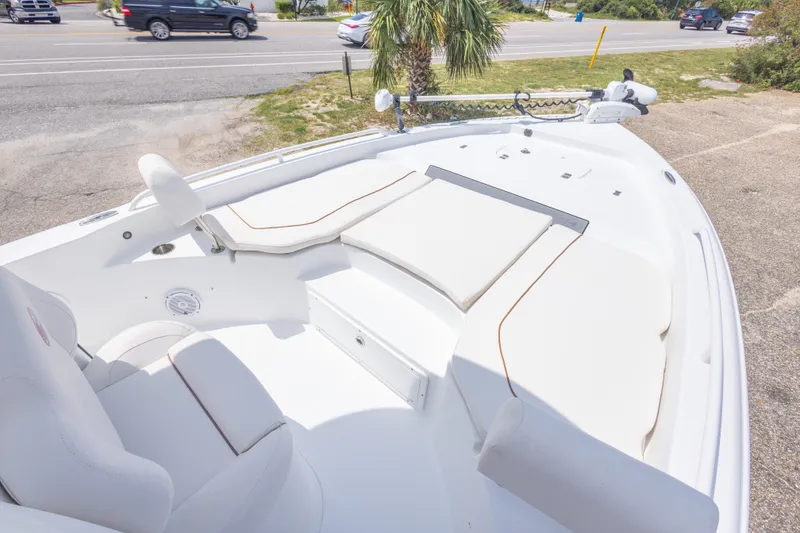 Slide: The Image of 2019 Sea Hunt BX25FS boat with cushioned seating and trolling motor, parked near a road. - 26