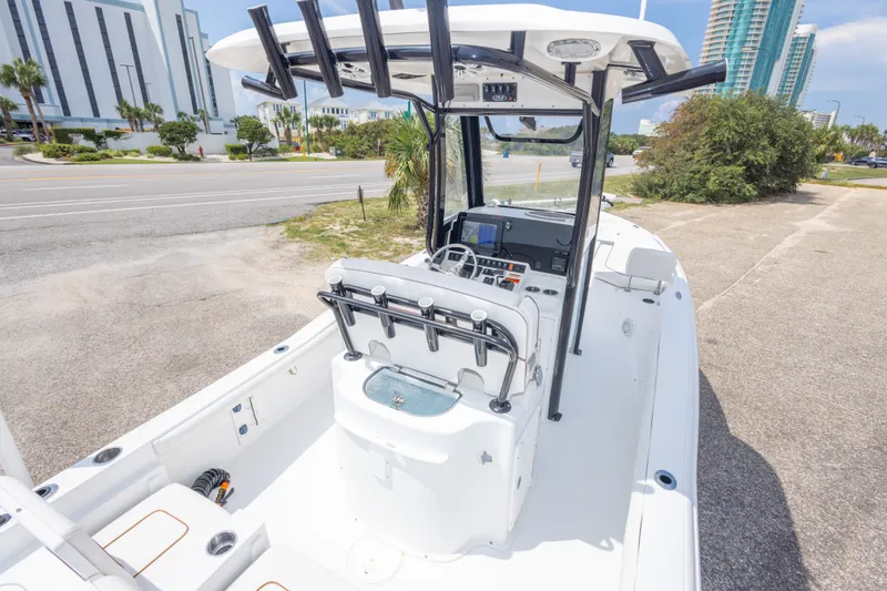 Slide: The Image of 2019 Sea Hunt BX25FS boat with center console, parked near a road with buildings. - 53