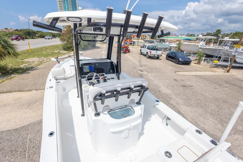 Slide: The Image of 2019 Sea Hunt BX25FS boat with center console, parked in a marina under a clear sky. - 52