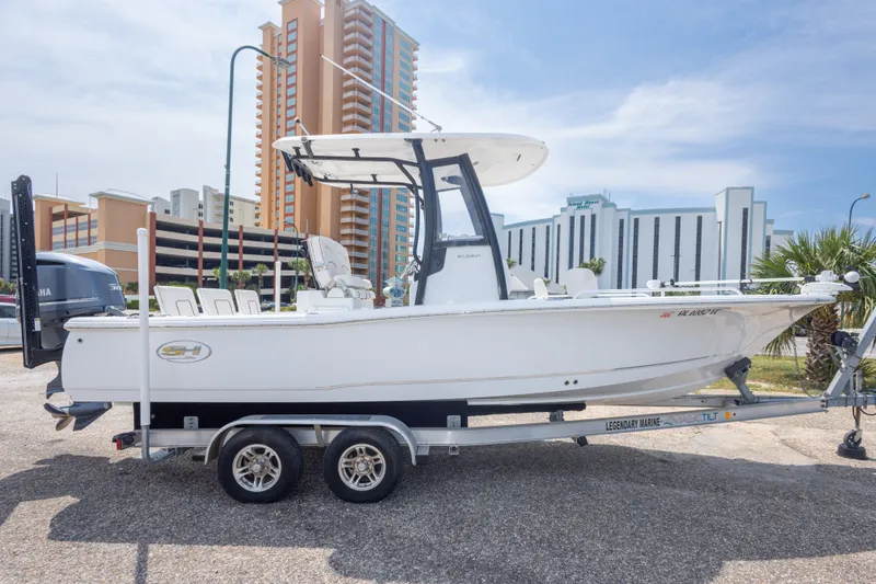 Slide: The Image of 2019 Sea Hunt BX25FS boat on trailer, parked near tall buildings. - 14