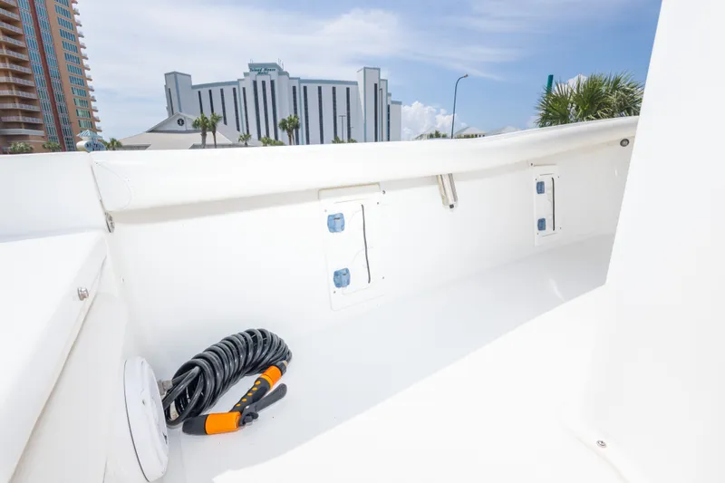 Slide: The Image of 2019 Sea Hunt BX25FS boat interior with hose and cityscape background. - 31
