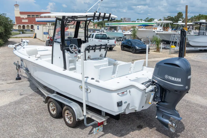 Slide: The Image of 2019 Sea Hunt BX25FS boat with Yamaha engine on trailer in marina setting. - 18
