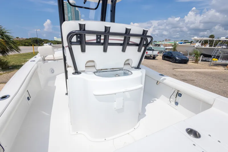 Slide: The Image of 2019 Sea Hunt BX25FS boat interior with rod holders and seating, parked near other boats. - 29
