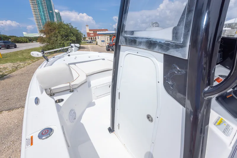 Slide: The Image of 2019 Sea Hunt BX25FS boat with sleek design, docked near a modern building. - 47
