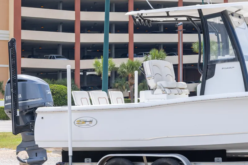 Slide: The Image of 2019 Sea Hunt BX25FS boat with Yamaha engine on trailer, parked near a building. - 4