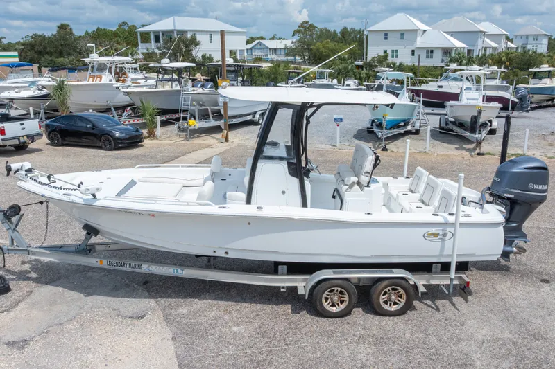 Slide: The Image of 2019 Sea Hunt BX25FS boat on trailer, parked in marina with other boats. - 15