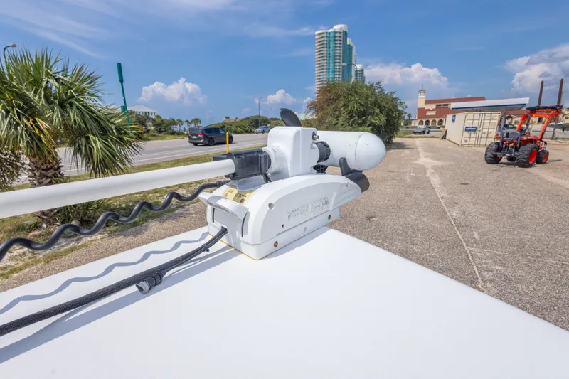 Slide: The Image of 2019 Sea Hunt BX25FS boat with trolling motor, parked near palm trees and buildings. - 45