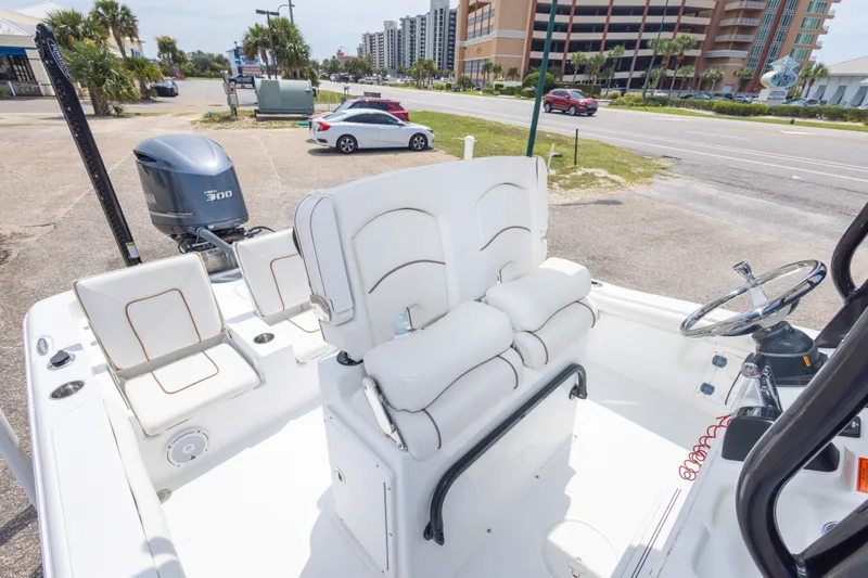 Slide: The Image of 2019 Sea Hunt BX25FS boat interior with seating and steering wheel, parked near a road. - 37